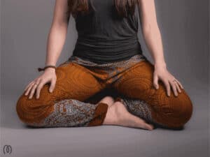 A woman cross legged using knowledge gained from Mindworks' Meditation Essentials