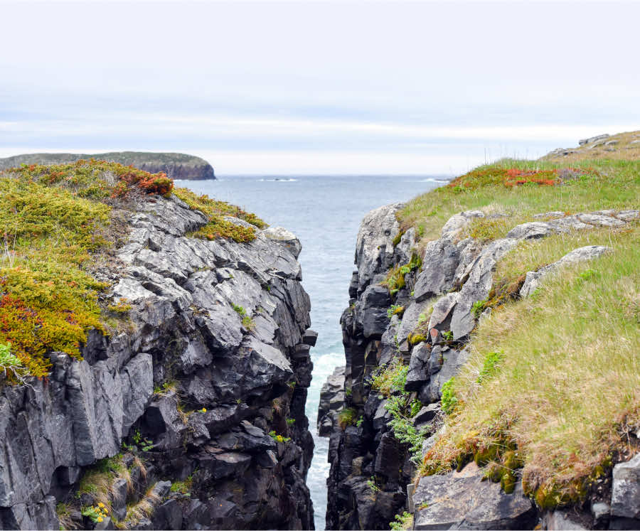 Two cliffs overlooking the ocean with a large gap between each