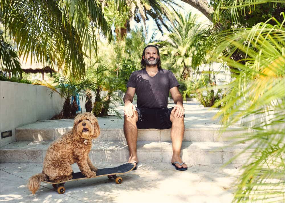 Man meditating using Mindworks Meditation training next to a dog on a skateboard.